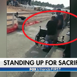 boy in wheelchair stands for National Anthem