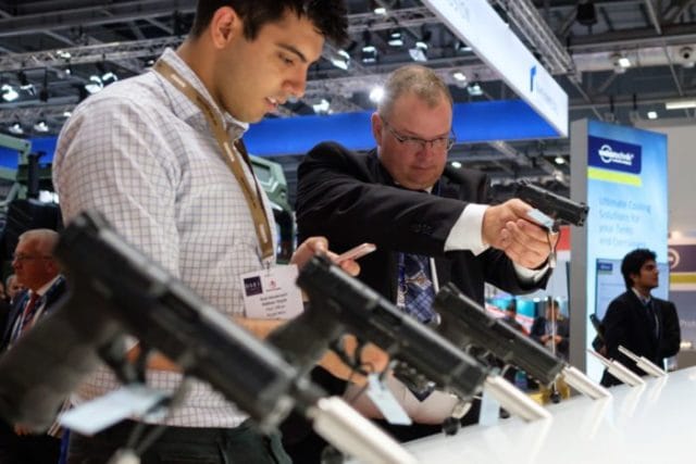 LONDON, ENGLAND - SEPTEMBER 12: Delegates try out handguns on the Heckler and Koch display stand at the DSEI event at the ExCel centre on September 12, 2017 in London, England. The annual weapons and security trade fair sees manufacturers of all aspects of military, naval, airforce and security from all over the world display their latest designs to delegates. (Photo by Leon Neal/Getty Images)