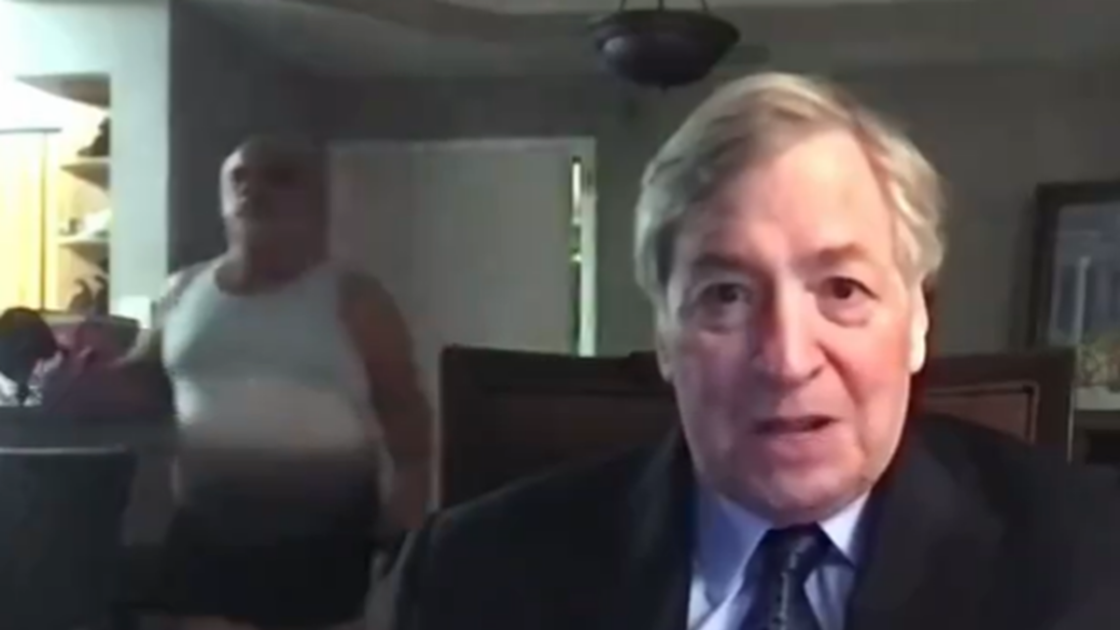 Newsmax viewers were left baffled when an interview with Dick Morris, a former adviser to Bill Clinton, was briefly interrupted when a man wearing only a tight tank top and black boxers sauntered past him.